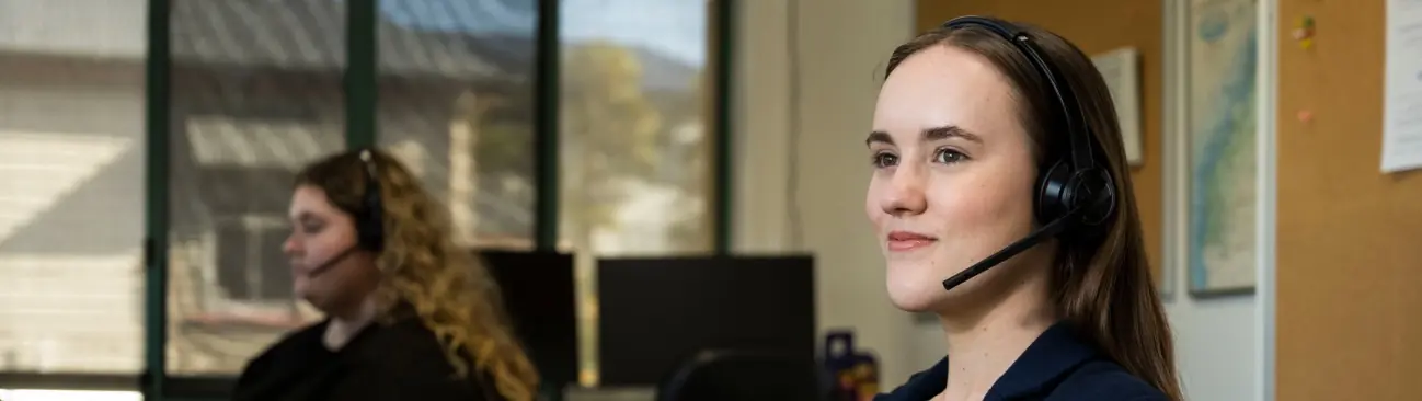 smiling woman wearing a headset in an office