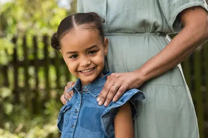 woman holding the shoulders of a young girl