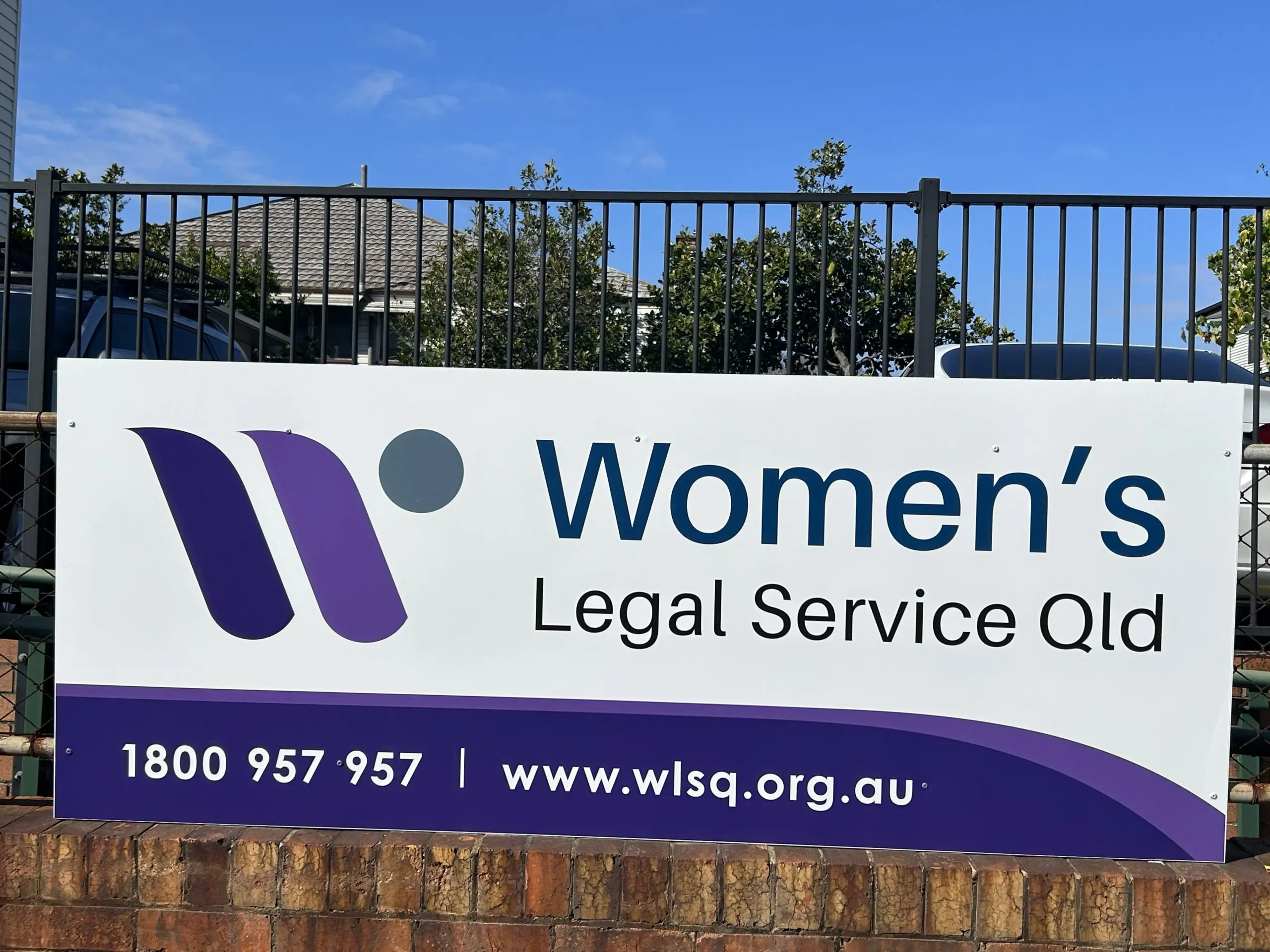 Women's Legal Service Qld promotional banner on a railing